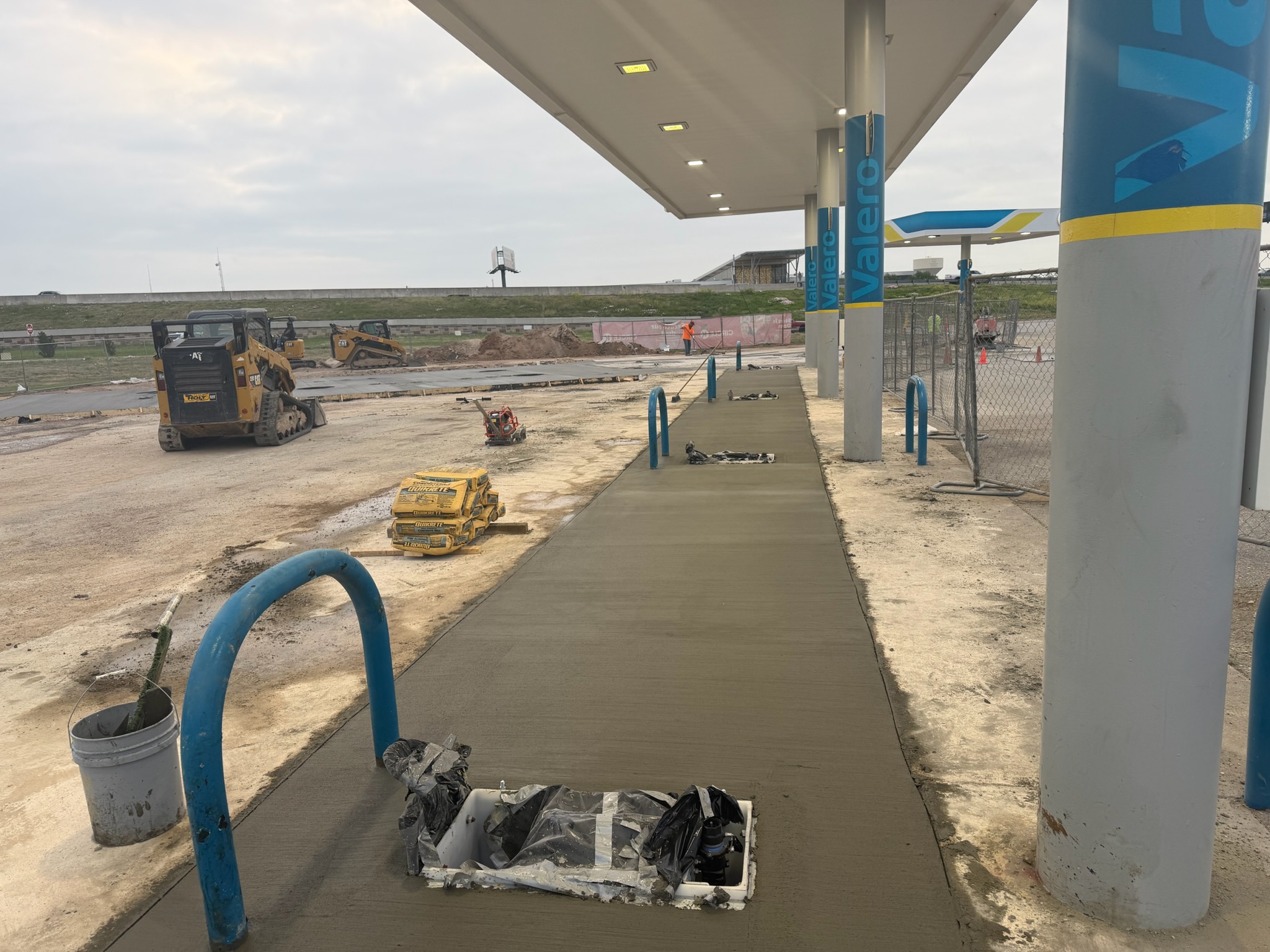 Freshly placed sidewalk concrete under a Valero canopy near Circle K in Lacy Lake View