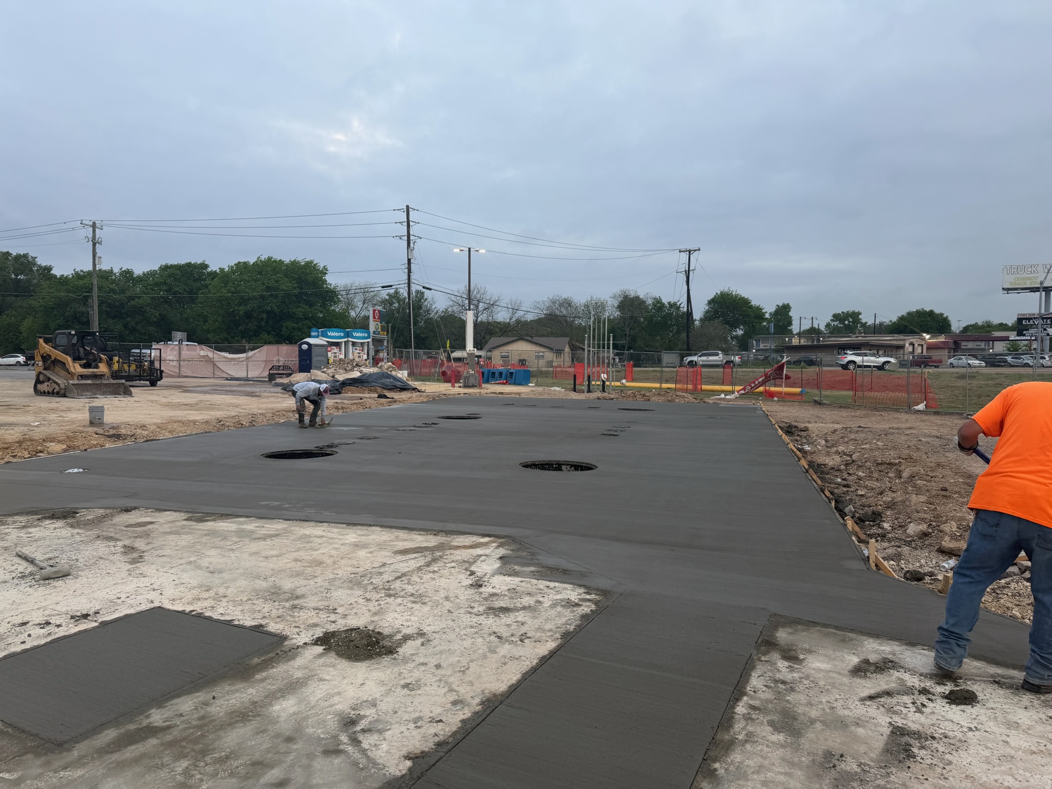Fresh commercial concrete slab being finished at the Lacy Lake View Valero site
