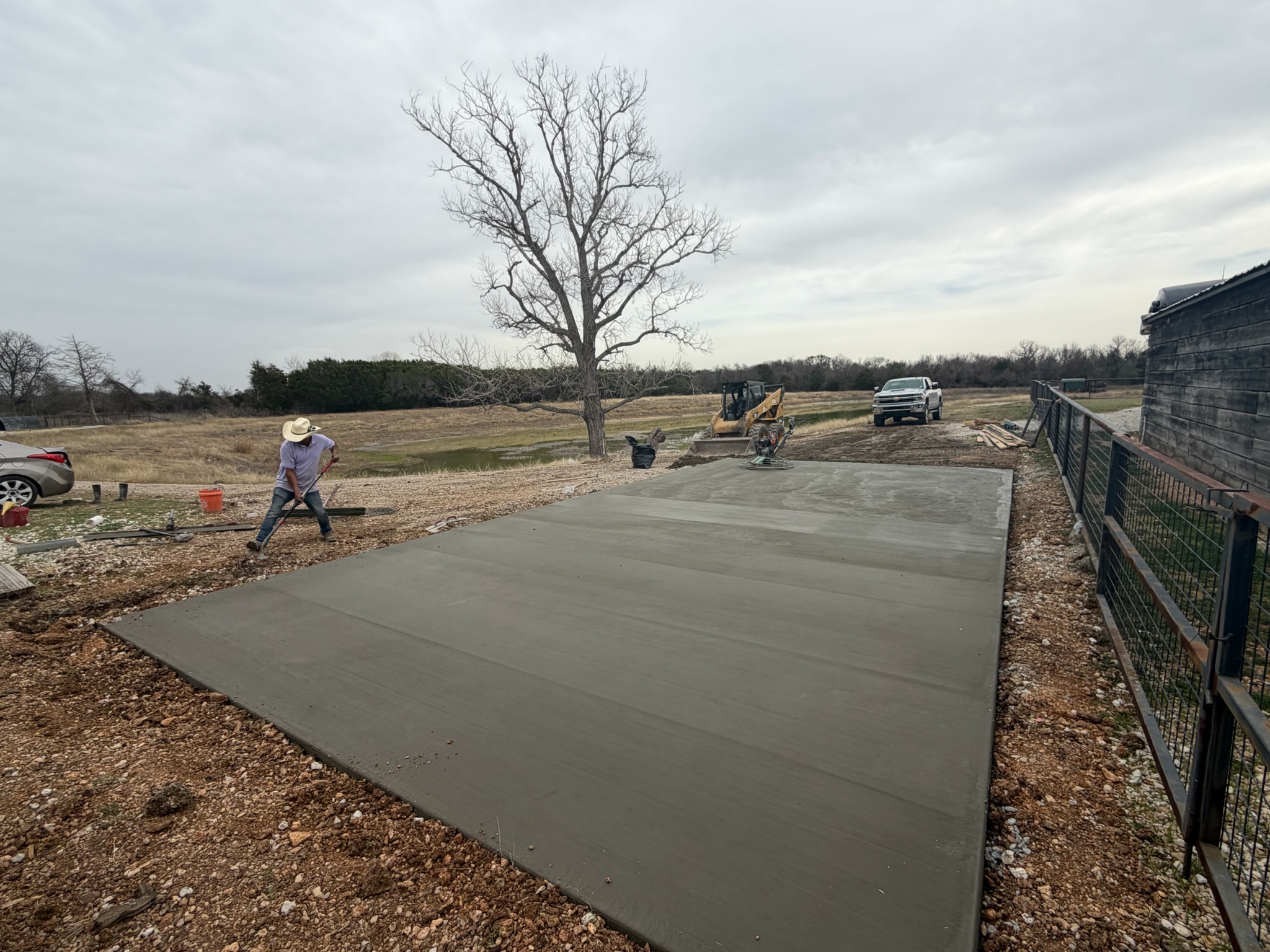 Hand-finished concrete edge meeting the surrounding gravel at the RV pad
