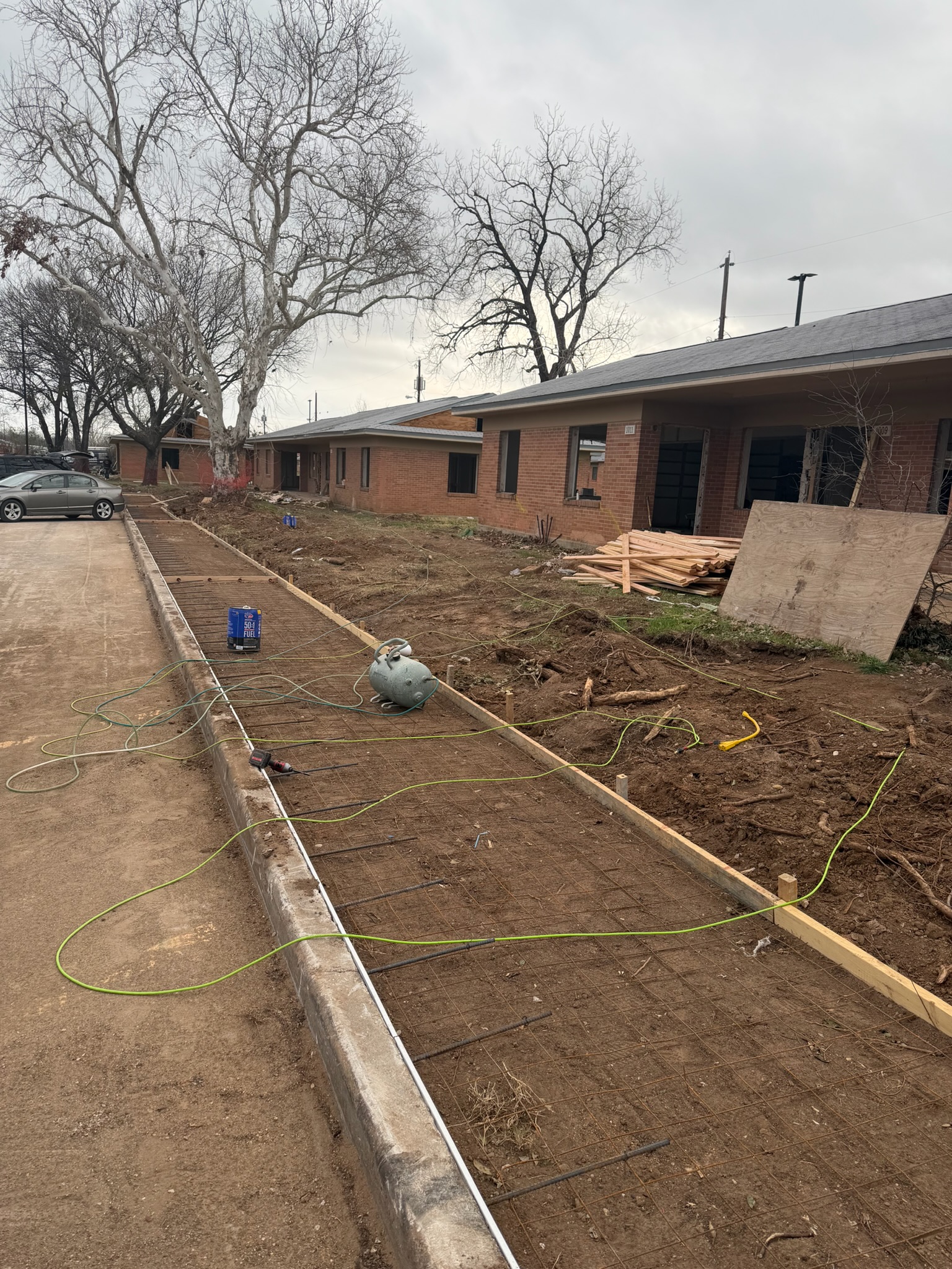 Crew distributing and striking fresh concrete on the Waco sidewalk