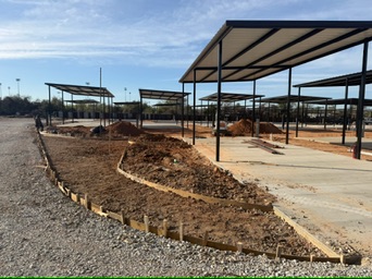 Concrete RV pads beneath metal covers with curved curb forms at Magnolia RV