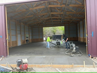 Walk-behind power trowel finishing the 2,500-square-foot Mount Calm shop slab