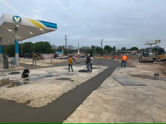 Crew floating fresh concrete in the Circle K apron and drive area