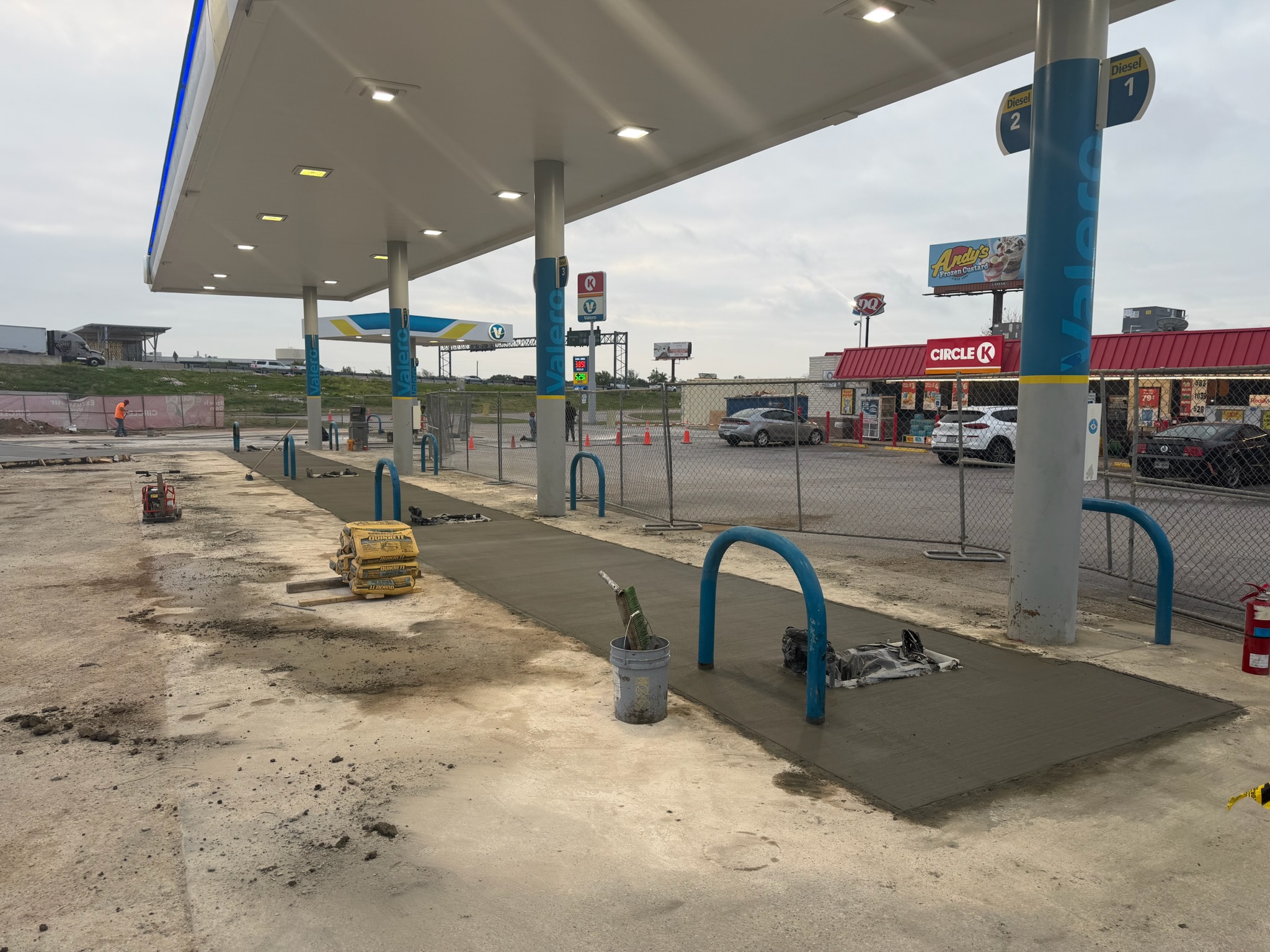 Circle K fuel-site flatwork beside active paving equipment in Lacy Lakeview